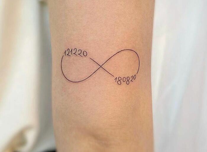Infinity tattoo with dates, symbolizing eternal creativity.