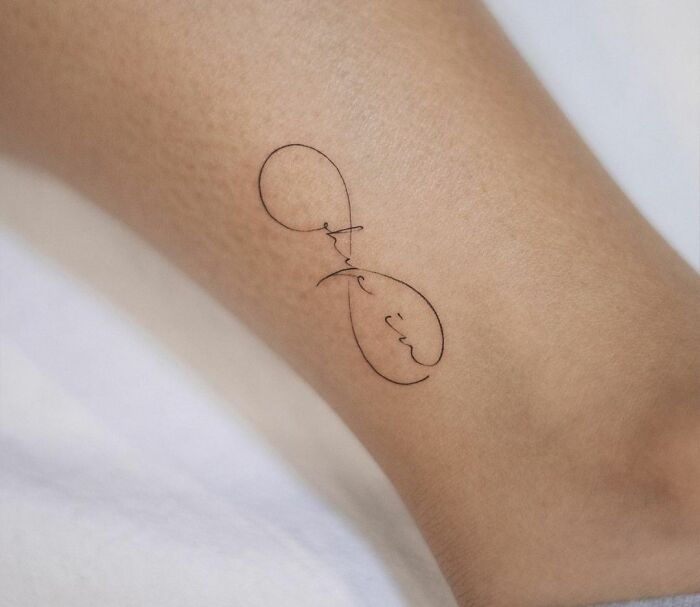 Minimal infinity tattoo with cursive design on ankle, showcasing creativity and elegance.