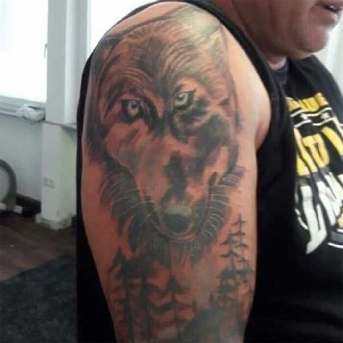 Wolf tattoo on arm, showcasing tattoo art with potential design flaws.