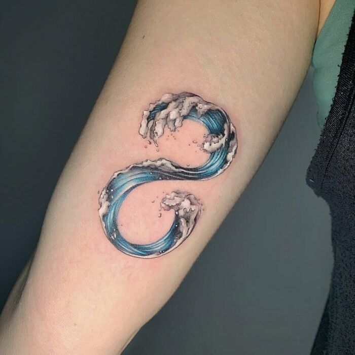 Infinity tattoo featuring ocean waves on an arm, showcasing creativity.
