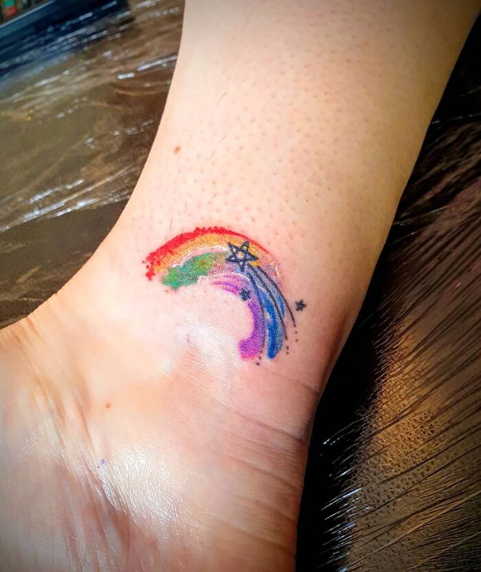 Colorful rainbow ankle tattoo with star details, showcasing ankle tattoo care and inspiration.
