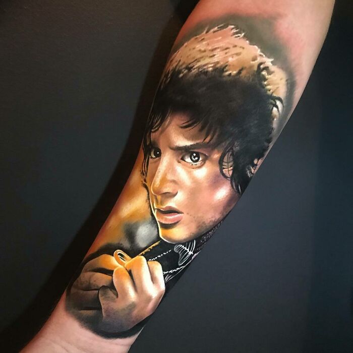 Realistic tattoo of a character from Lord of the Rings on an arm, showcasing intricate artwork.