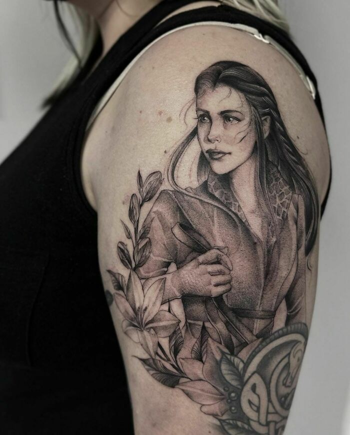 Tattoo of a detailed character from Lord of the Rings, featuring intricate floral designs on a person's arm.