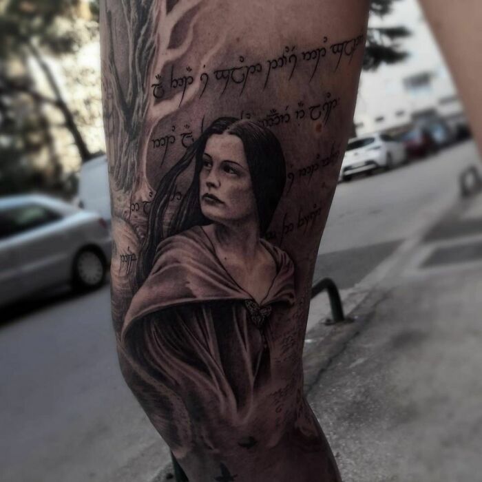 Anime-inspired Lord of the Rings tattoo featuring a hooded figure and Elvish script on a leg.