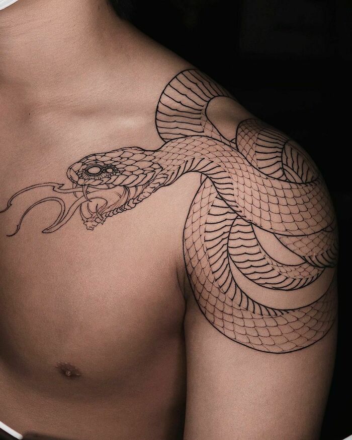 Snake tattoo in black ink on a person's shoulder, showcasing intricate scale details and coiled design.