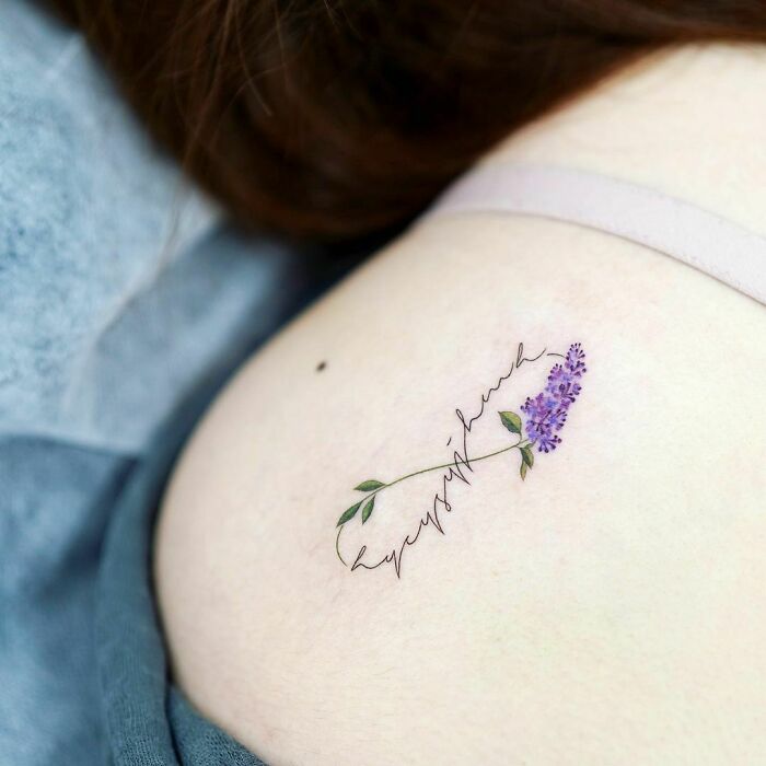 Elegant infinity tattoo with purple flowers, symbolizing eternal creativity on skin.