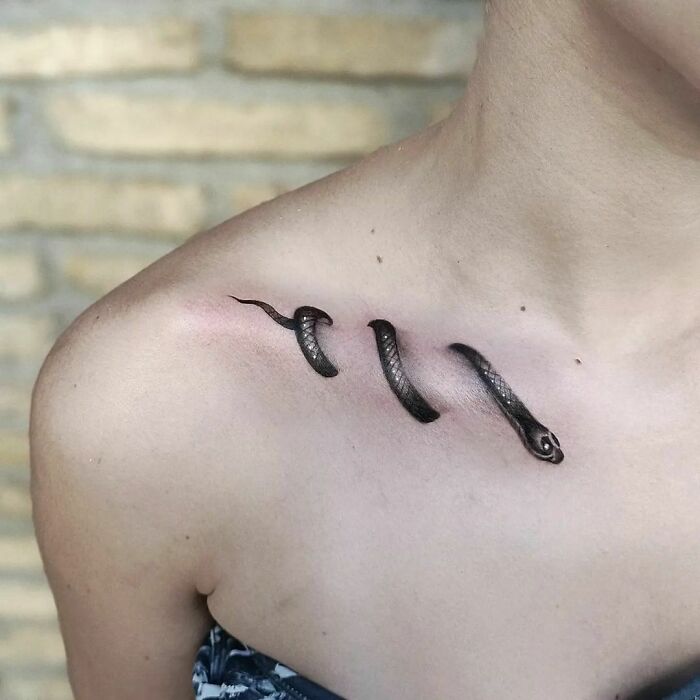 Snake tattoo design on a person's shoulder, showcasing detailed scales and curvature.