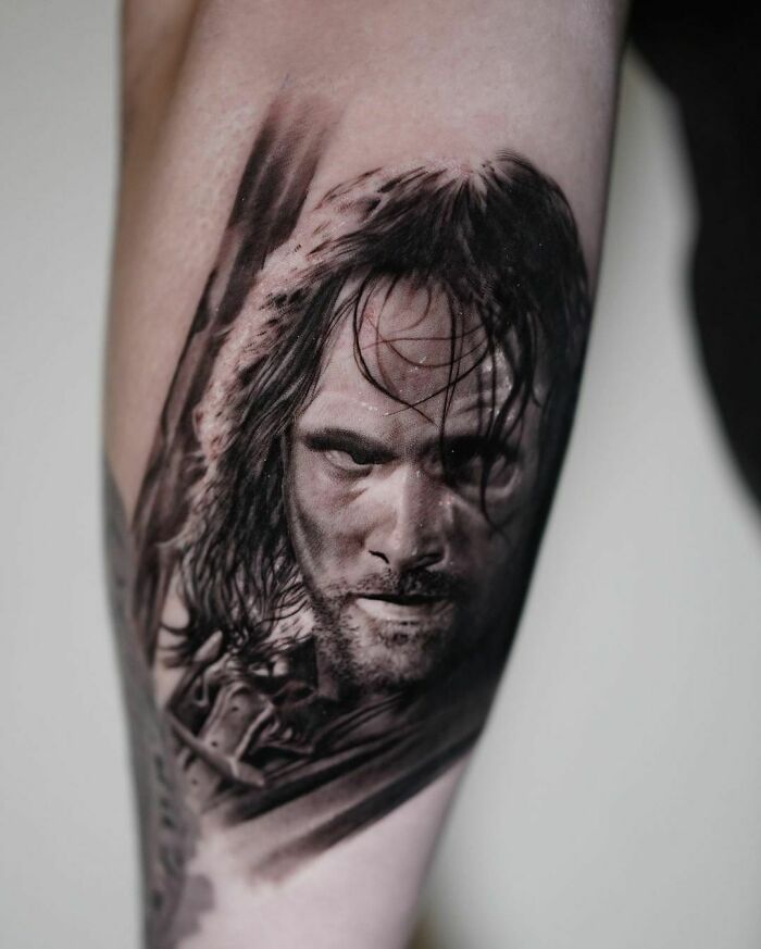 A detailed black and gray tattoo featuring a character from Lord of the Rings on a person's arm.