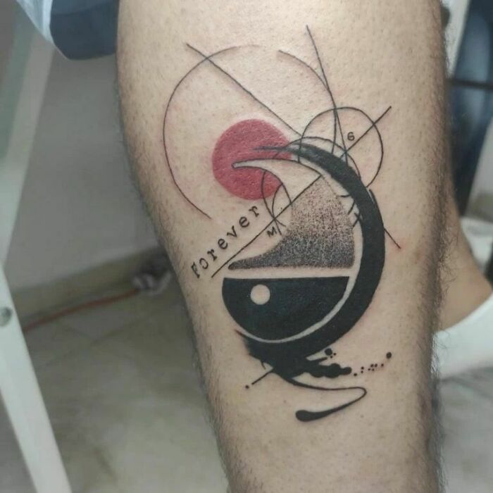 Abstract yin yang tattoo on leg with geometric elements and text "Forever."
