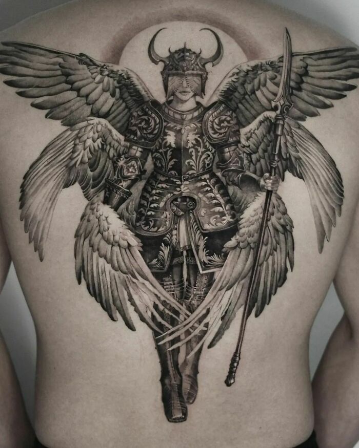Gothic tattoo of a winged warrior in detailed armor covering a person's back.