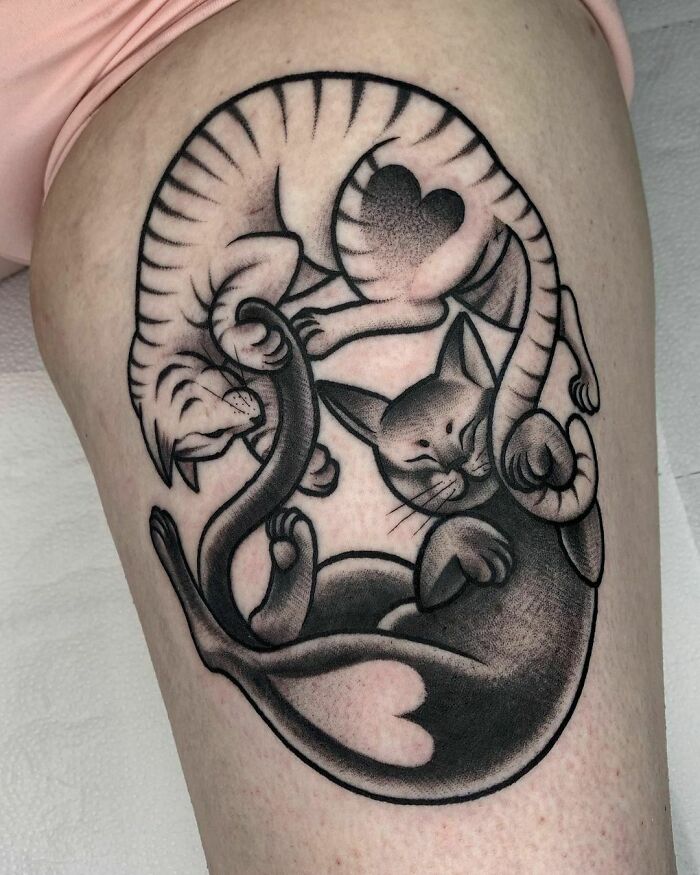 Yin Yang tattoo featuring intertwined cats with heart patterns, symbolizing duality and harmony.