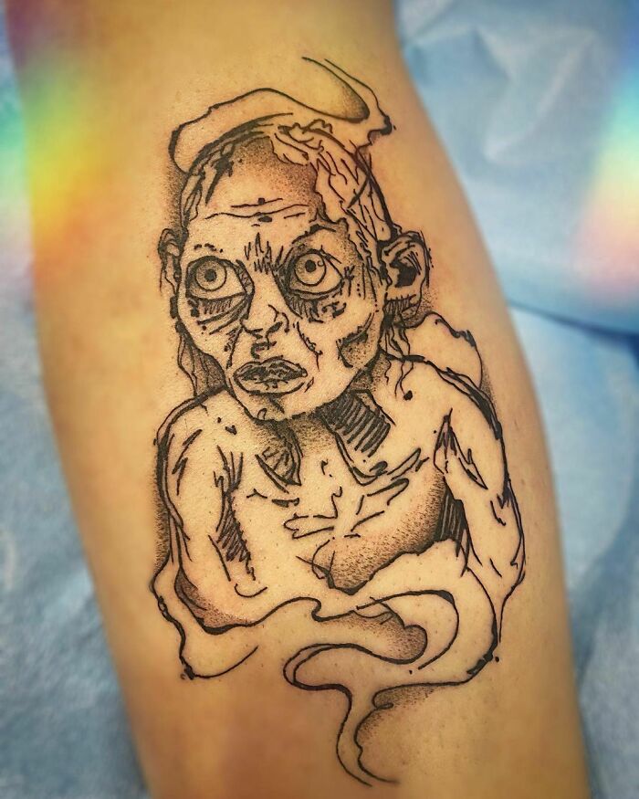 Gollum tattoo in black ink on skin, inspired by Lord of the Rings, featuring detailed linework and shading.