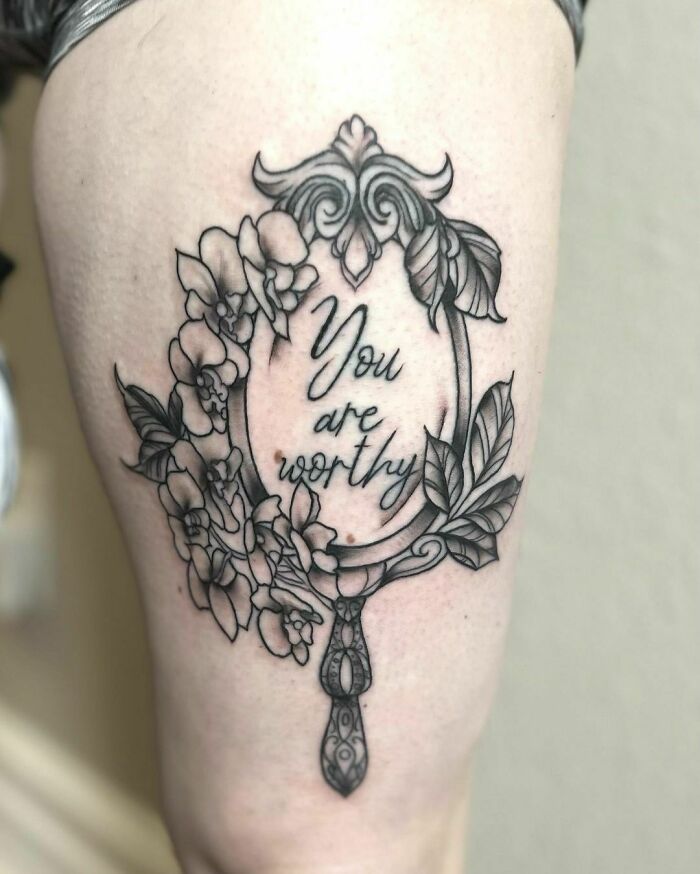 Ornate mirror tattoo on skin with floral design and "You are worthy" text, symbolizing mental health healing.