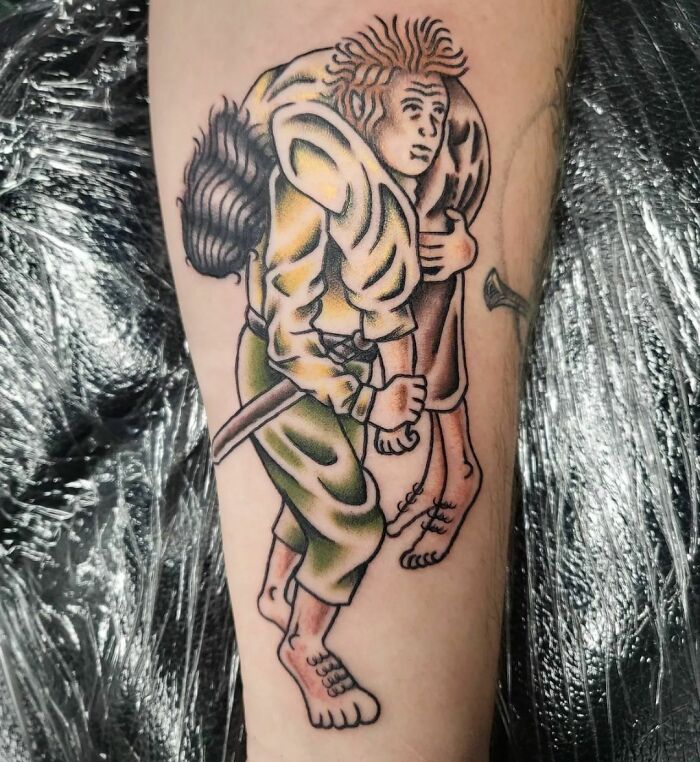 Lord of the Rings tattoo depicting a character carrying another, in colorful ink on forearm.
