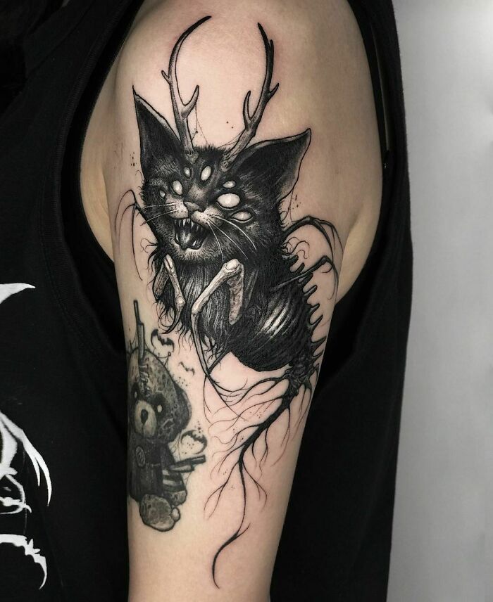 Gothic tattoo featuring a mythical cat creature with antlers on a person's arm.