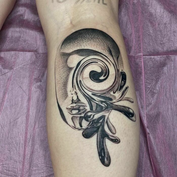 Abstract tattoo featuring a swirling pattern with black ink on skin, embodying artistry and self-expression.