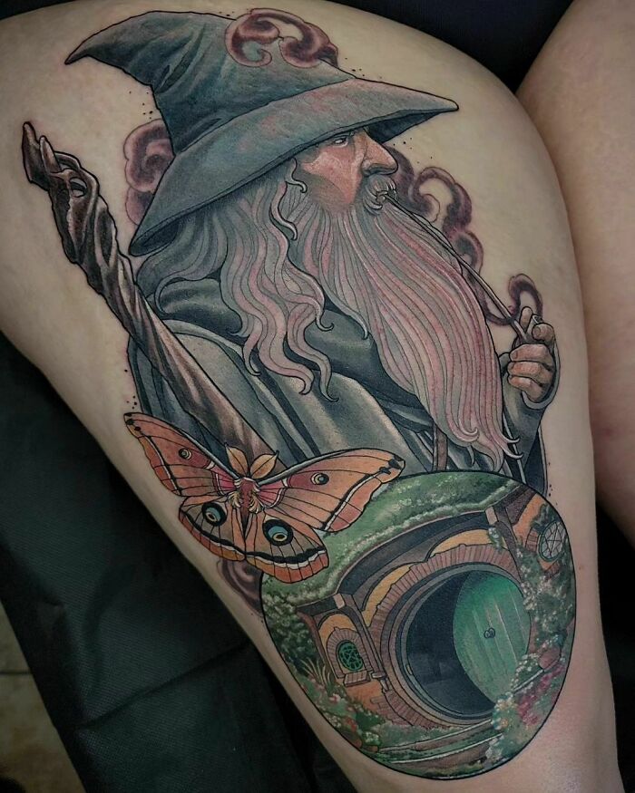Wizard-themed Lord of the Rings tattoo featuring a bearded figure, moth, and round door, showcasing detailed fantasy art.