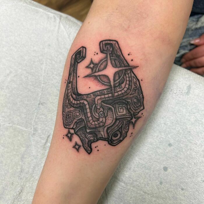 The Legend Of Zelda intricate video game tattoo with geometric patterns and star details on a person's arm, showcasing gamer artistry.