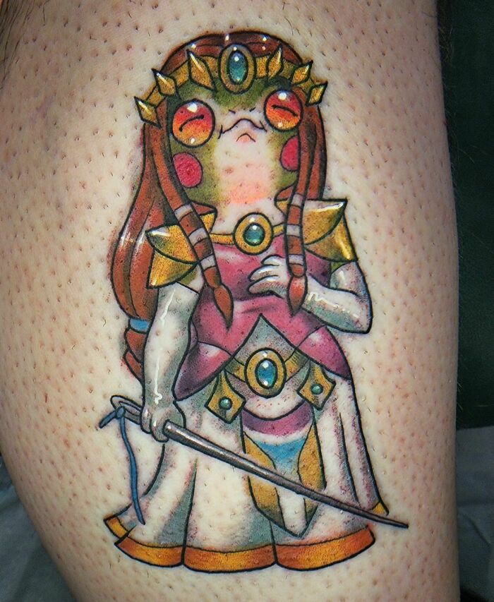 Colorful The Legend Of Zelda video game tattoo featuring a fantasy character wearing a crown and holding a staff.