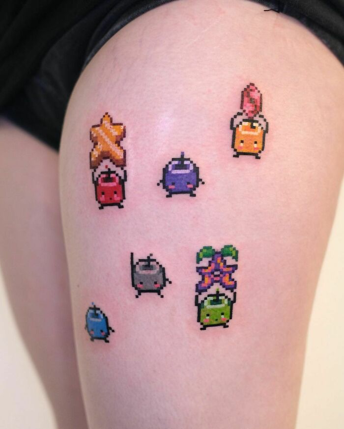 Pixel art Stardew Valley video game tattoos on skin, showcasing colorful characters in a minimalist style.