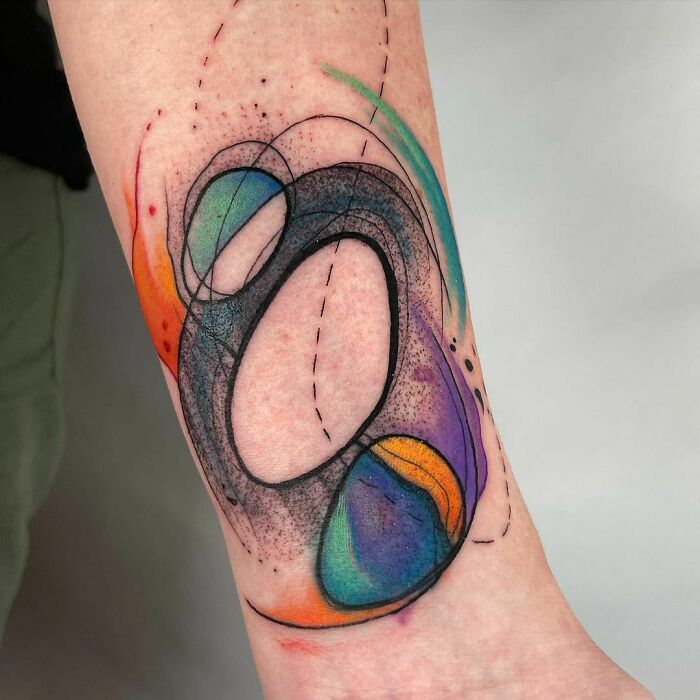 Colorful abstract tattoo design on arm showcases artistry and self-expression.
