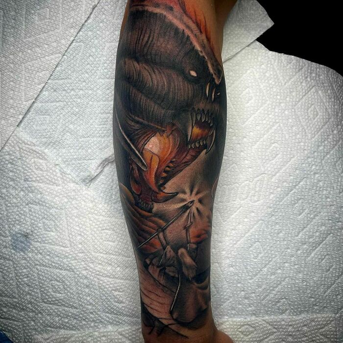 Lord of the Rings tattoo featuring a detailed monster design on a forearm.