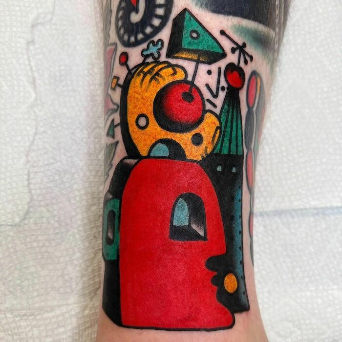 Abstract tattoo art with bold colors and geometric shapes on forearm.