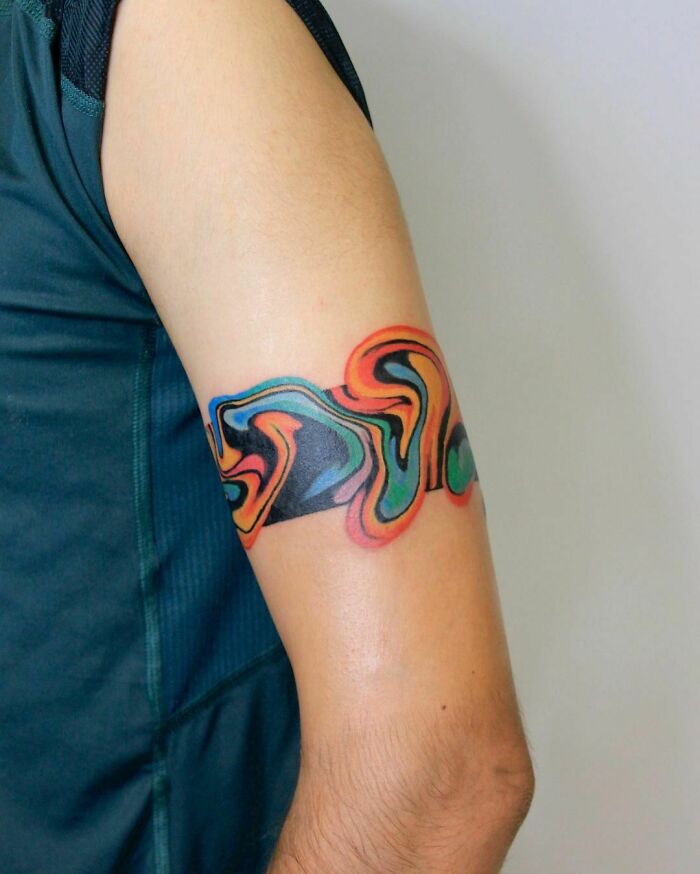 Abstract tattoo with colorful swirling patterns on a person's arm, showcasing artistry and self-expression.