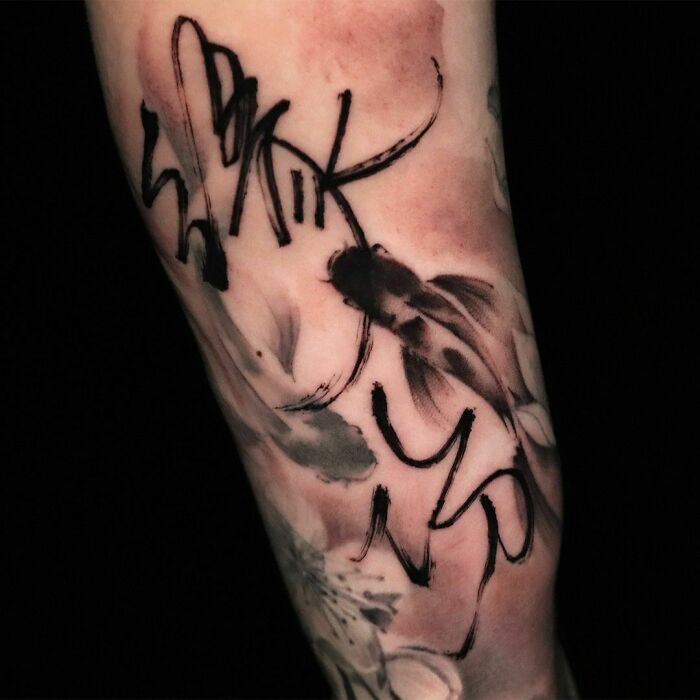 Abstract tattoo design on forearm with artistic brush strokes and black ink patterns, showcasing self-expression.