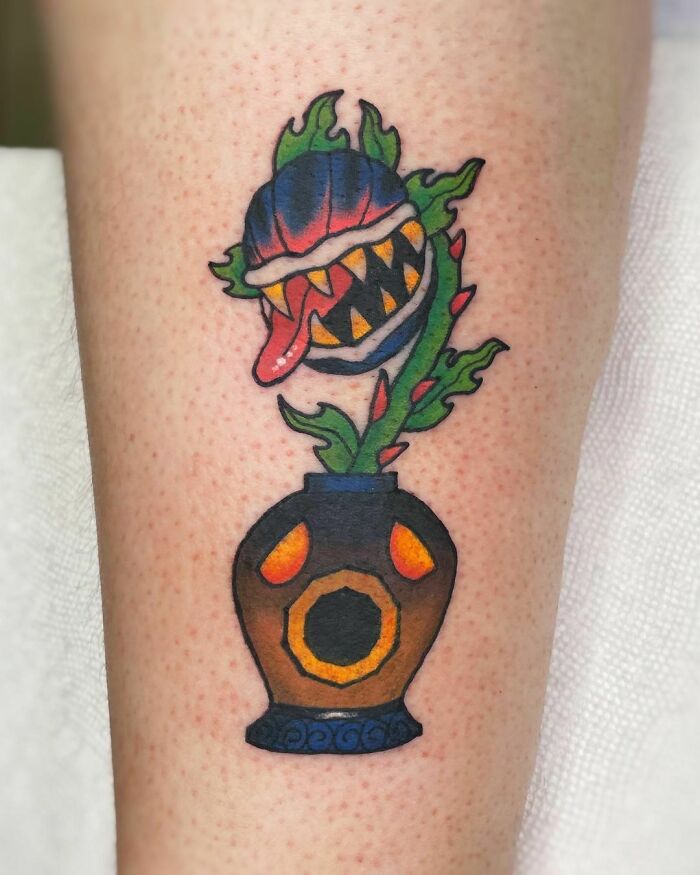 Colorful The Legend Of Zelda video game tattoo featuring a carnivorous plant in a pot on forearm.