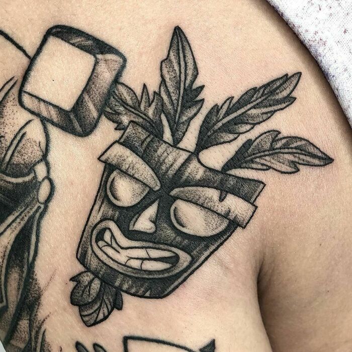 Crash Bandicoot video game tattoo featuring a tribal mask design on skin.