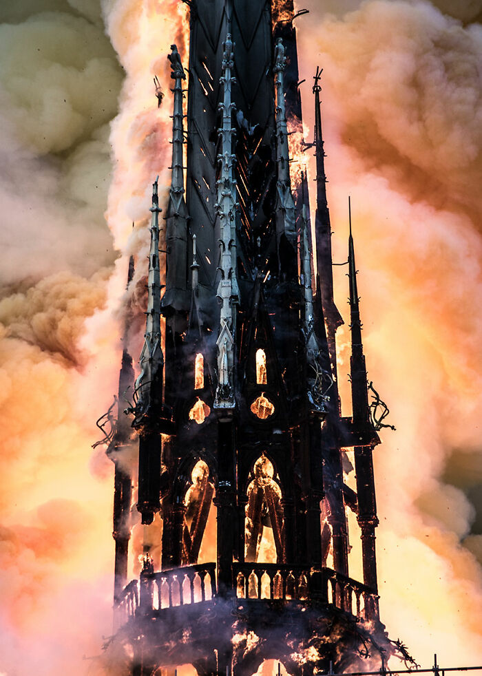 Gothic-style building spire engulfed in flames and smoke, illustrating the best pictures chosen by Wikimedia Commons community.