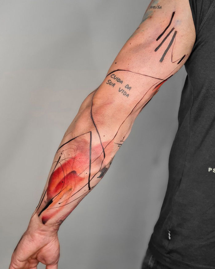 Abstract tattoo on forearm with red and black lines, showcasing unique artistry and self-expression.