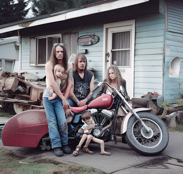Family posing awkwardly by a motorcycle in front of their home, showcasing a humorous AI art fail.