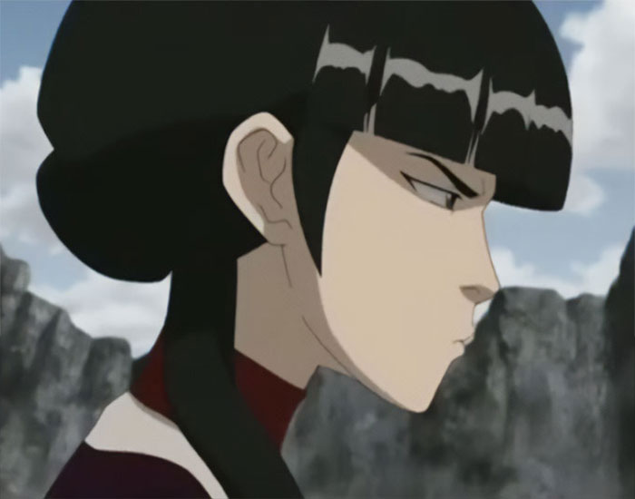 Mai from Avatar The Last Airbender looking angry and serious with a rocky landscape background.