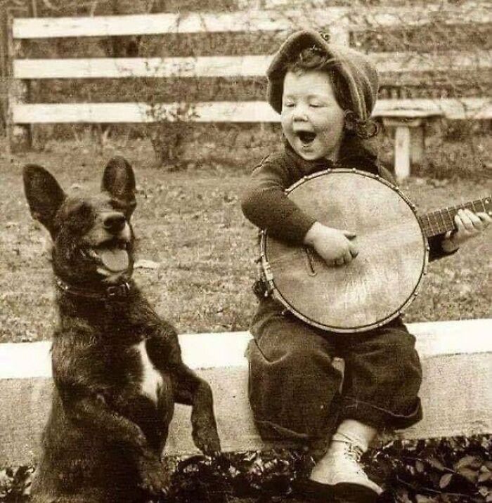 A Young Boy Playing The Banjo With His Dog, Circa Early 1900s