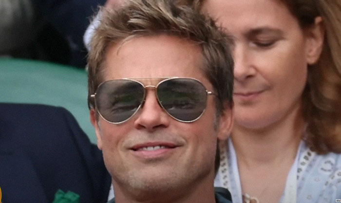 Brad Pitt at Wimbledon, wearing sunglasses and a casual outfit, creating buzz over his age.
