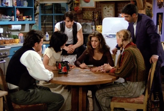 All friends sitting at the table cheering up Rachel 