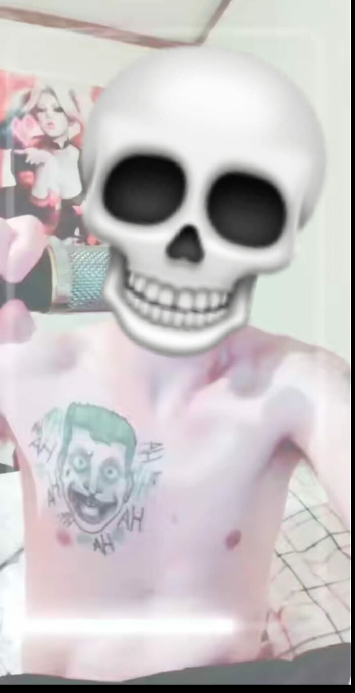 Person with a poorly done clown tattoo on their chest, face covered with a skull emoji.