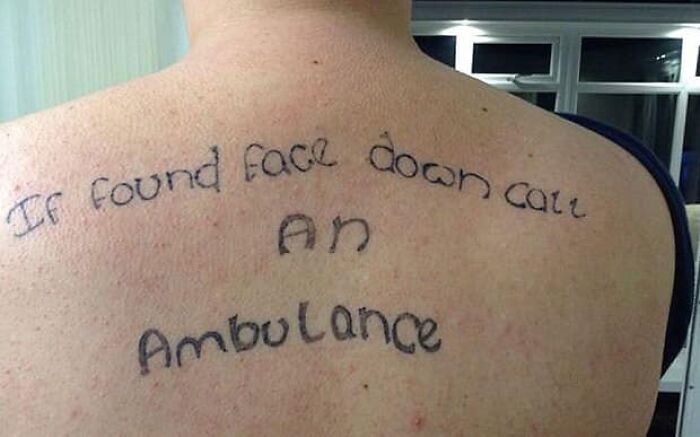 Back tattoo with humorous text: "If found face down call an ambulance."
