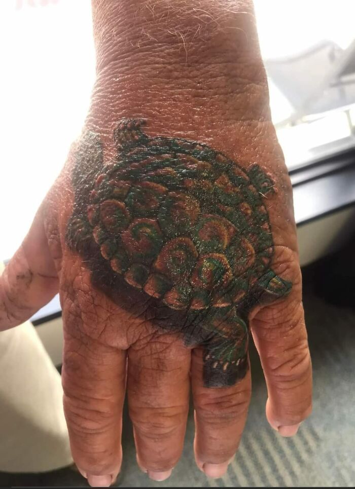 Turtle tattoo on a person's hand, showcasing humorous tattoo art.