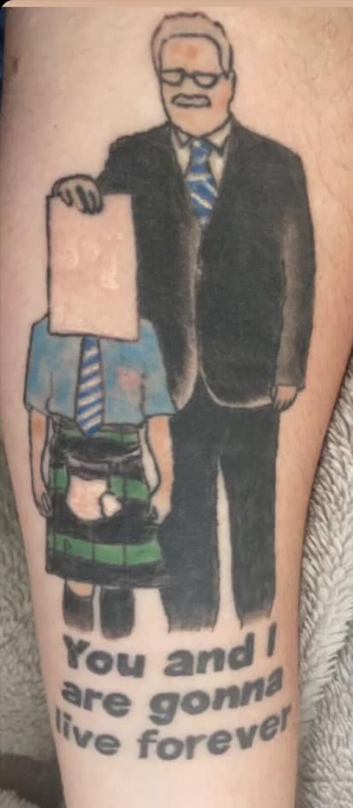 Funny tattoo with two faceless figures, one in a suit, the other in a kilt, with text "You and I are gonna live forever."