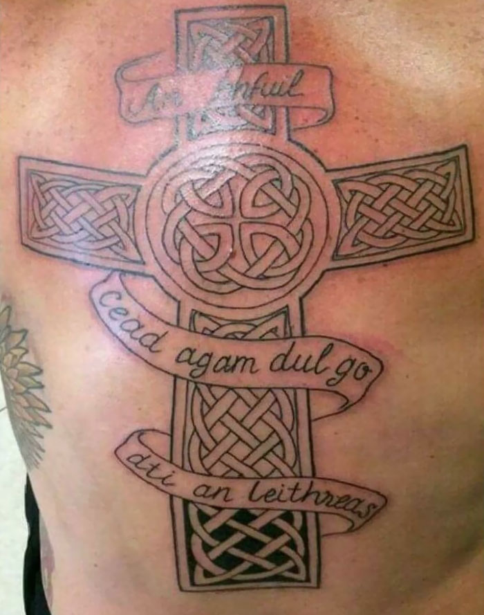 Celtic cross tattoo with ornate design and banners, showcasing common inked mistakes with permanent tattoos.