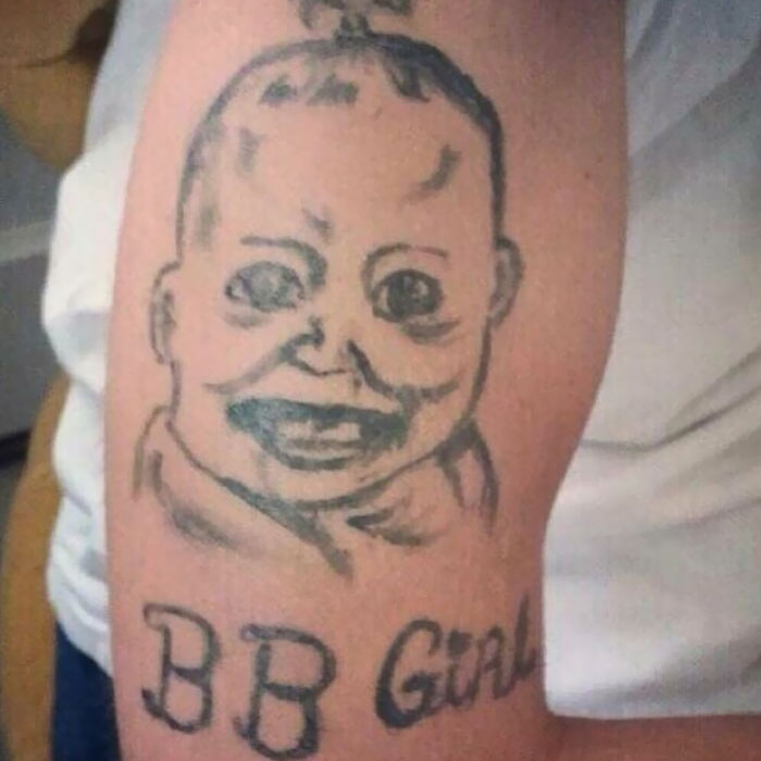 Tattoo of a baby's face above the words "BB Girl" on a person's arm, representing a permanent inked mistake.