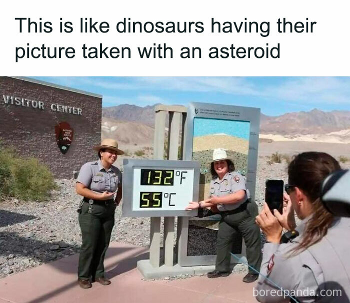 Two park rangers pose by a digital thermometer reading 132°F in a desert, illustrating science humor jokes.