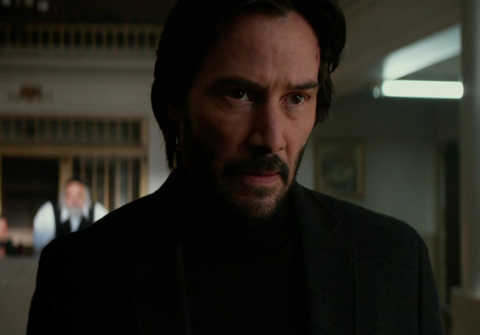 Keanu Reeves wearing black suit