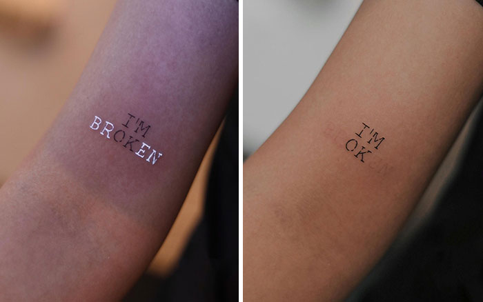 Two arms showing mental health tattoos: one says "I'M BROKEN", the other "I'M OK."