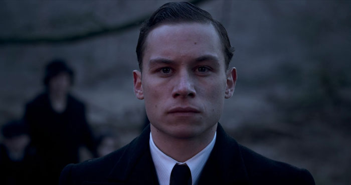 Michael Shelby standing and looking straight with no expression