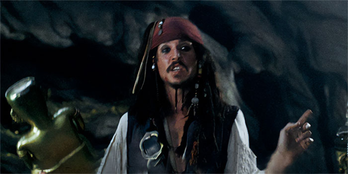 Jack Sparrow speaking in a dark cave scene, capturing iconic Pirates of the Caribbean quotes treasure moments.
