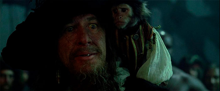 Hector Barbossa with his monkey in a dark setting, capturing a moment from Pirates of the Caribbean quotes treasure.